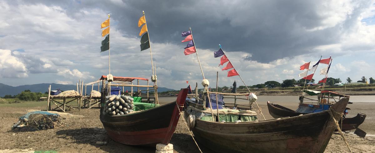 Vessels in the mud below ominous clouds