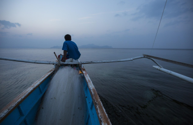 Fisher sitting atop fishing boat