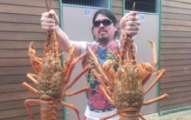man holding two lobsters